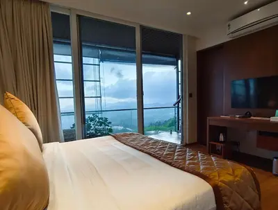 a bedroom with a bed and a large window at Stays By MindEscapes in Ketti