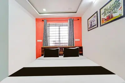a bedroom with a bed and a window at Super Hotel O Vijaynagar Road Formerly Anmol Peace Stay in Ooty
