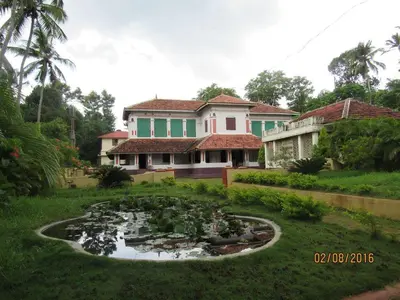 a house with a pond in front of a house at Srivilas in Pudunagaram