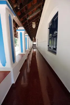an empty hallway of a building with blue and white walls at Srivilas in Pudunagaram
