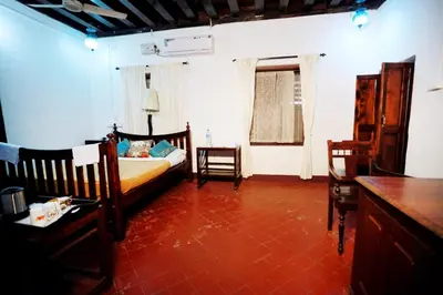 a bedroom with a bed and a table and chairs at Srivilas in Pudunagaram