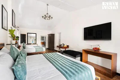 a hotel room with a bed and a tv at StayVista at The Alcove with Breakfast & BBQ Grill in Ooty