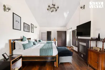 a bedroom with a large bed and a tv at StayVista at The Alcove with Breakfast & BBQ Grill in Ooty