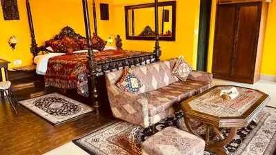 a living room with a couch and a bed at Habba Kadal Kashmiri Heritage Hotel & Hub in Coonoor