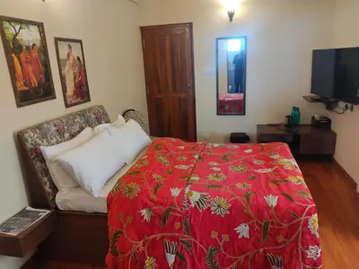 a bedroom with a bed with a red blanket at Habba Kadal Kashmiri Heritage Hotel & Hub in Coonoor