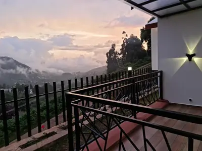 a balcony of a house with a view of the mountains at Sky Sketch in Kodaikānāl