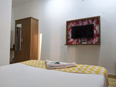 a bedroom with a bed and a flat screen tv at Cherai Blue View Beach Resort in Cochin