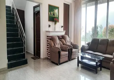 a living room with two couches and a fireplace at Velus Bungalow Ooty in Ooty