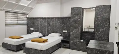 two beds in a room with a mirror at MAYPORT HERITREAT in Alwaye