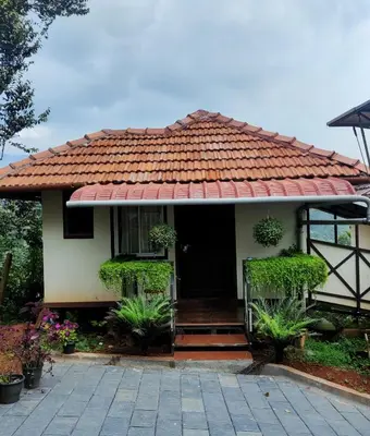 a small house with a red roof at Raymond's Holiday Homes in Vythiri