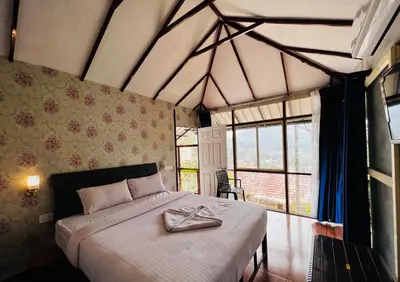 a bedroom with a bed with a robe on it at Raymond's Holiday Homes in Vythiri