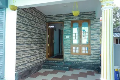 a front porch of a house with a wooden door at 7coloursholidays in Kanthalloor
