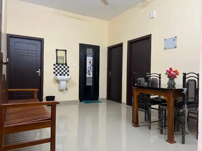 a room with three doors and a table and chairs at Fathima Apartments in Iritti