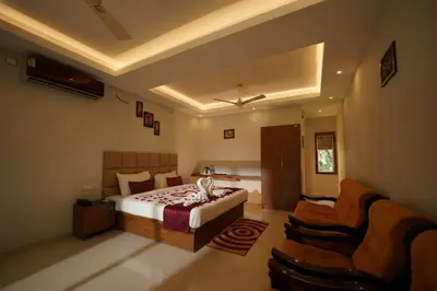 a large bedroom with a bed and a couch at Oxyvalley Resort in Attappādi