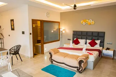 a bedroom with a large bed with red pillows at Oxyvalley Resort in Attappādi