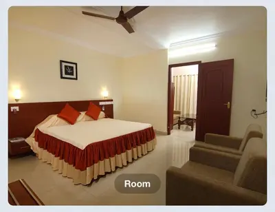 a bedroom with a bed and a ceiling fan at Hotel Sasthapuri in Kozhikode