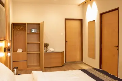 a bedroom with a bed and a closet and a door at HILUX COURTYARD in Palakkad