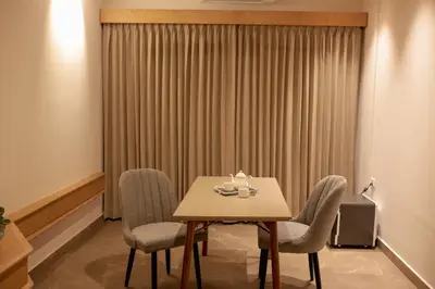 a room with a table and chairs and a window at HILUX COURTYARD in Palakkad