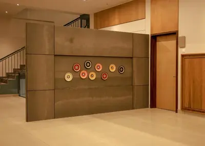 a lobby with a wall with a bunch of plates on it at HILUX COURTYARD in Palakkad