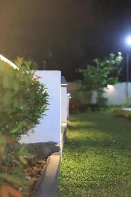 a white wall in a yard at night at Seeheim Resorts in Athirappilly