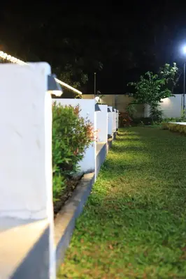 a white fence in a yard at night at Seeheim Resorts in Athirappilly