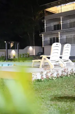 two white chairs sitting on the edge of a pool at Seeheim Resorts in Athirappilly