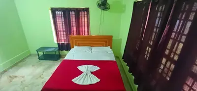 a bedroom with a bed with a red and white blanket at Empire HomeStay in Kalpetta