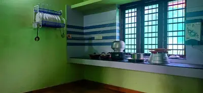 a kitchen with a counter with pots and pans at Empire HomeStay in Kalpetta