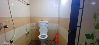a bathroom with a toilet in a shower stall at Empire HomeStay in Kalpetta