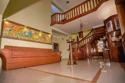 a living room with a couch and a painting on the wall at KRISHNAGIRI homes in Guruvāyūr