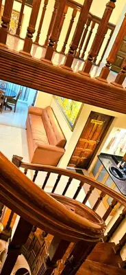 a wooden staircase with a couch in a house at KRISHNAGIRI homes in Guruvāyūr