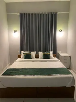 a bedroom with a large bed in front of a window at HOLLYWOOD Rooms in Sultan Bathery