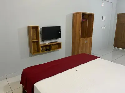 a bedroom with a bed and a flat screen tv at HOLLYWOOD Rooms in Sultan Bathery
