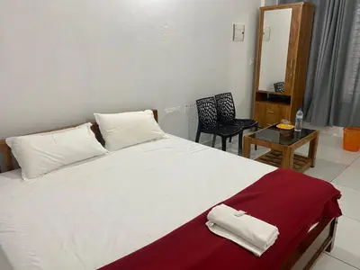a bedroom with a large white bed and a table at HOLLYWOOD Rooms in Sultan Bathery