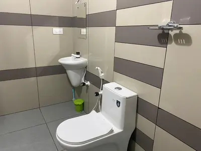 a bathroom with a toilet and a sink at HOLLYWOOD Rooms in Sultan Bathery