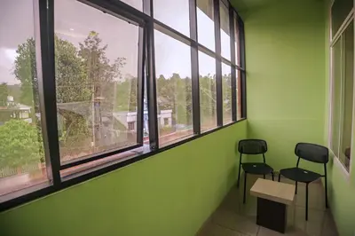 two chairs in an empty room with windows at zanbaq residency in Vythiri