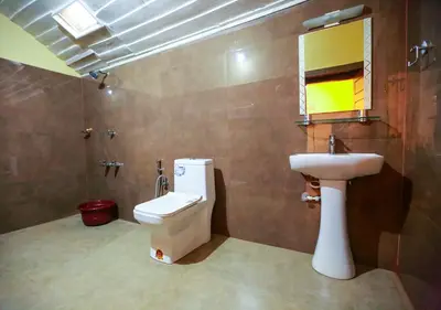 a bathroom with a sink and a toilet and a mirror at Chandragiri Heritage Bungalow and Cottages in Vaduvanchal