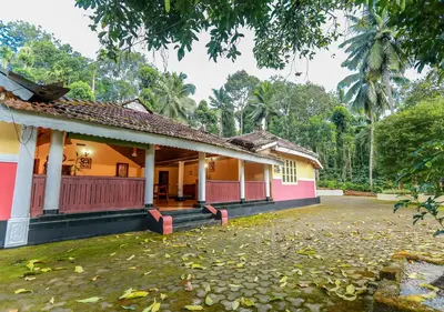 a house with pink and orange paint at Chandragiri Heritage Bungalow and Cottages in Vaduvanchal