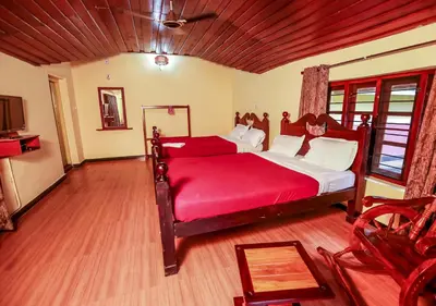 a bedroom with a large bed with a red blanket at Chandragiri Heritage Bungalow and Cottages in Vaduvanchal