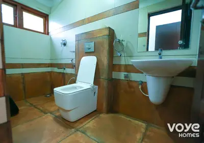 a bathroom with a toilet and a sink at Chandragiri Heritage Bungalow and Cottages in Vaduvanchal