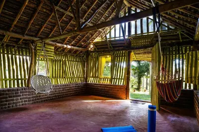 a large room with a hammock in a building at VanaJyotsna Forest Home in Marayoor