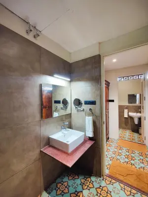 a bathroom with a sink and a toilet at Ibex River Resort, Pollachi in Coimbatore