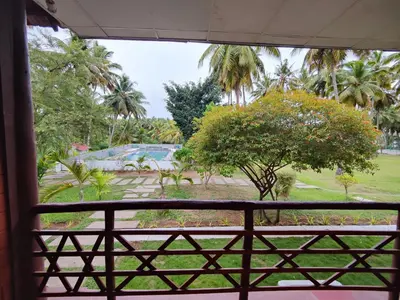 a view of a park from a window at Ibex River Resort, Pollachi in Coimbatore