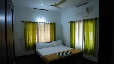 a small bedroom with green curtains and a bed at Thas apartment near rajagiri hospital in Alwaye