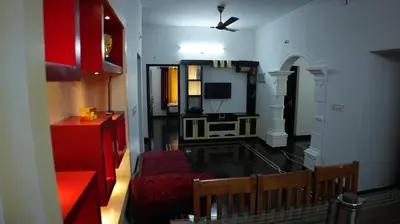 a living room with a red couch and a tv at Thas apartment near rajagiri hospital in Alwaye