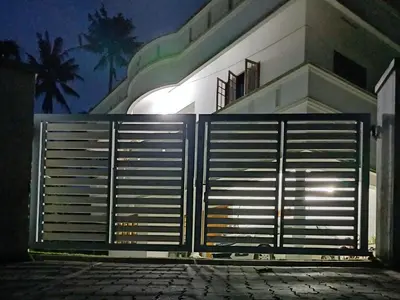 a gate in front of a building at night at Thas apartment near rajagiri hospital in Alwaye
