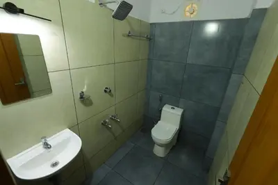 a bathroom with a toilet and a sink at Aldora Airport Residency in Nedumbassery
