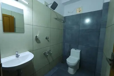 a bathroom with a sink and a toilet and a mirror at Aldora Airport Residency in Nedumbassery