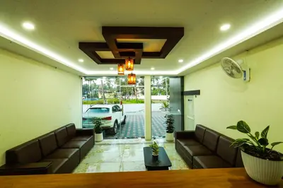 a lobby with couches and a table and a car at Aldora Airport Residency in Nedumbassery