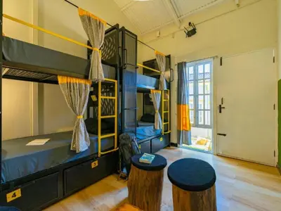a room with two bunk beds and two stools at The Hosteller Ooty in Ooty